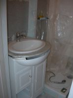 Un lavabo non fixé, un polyane en guise de paroi vitrée. Salle d&lsquo;eau à finir